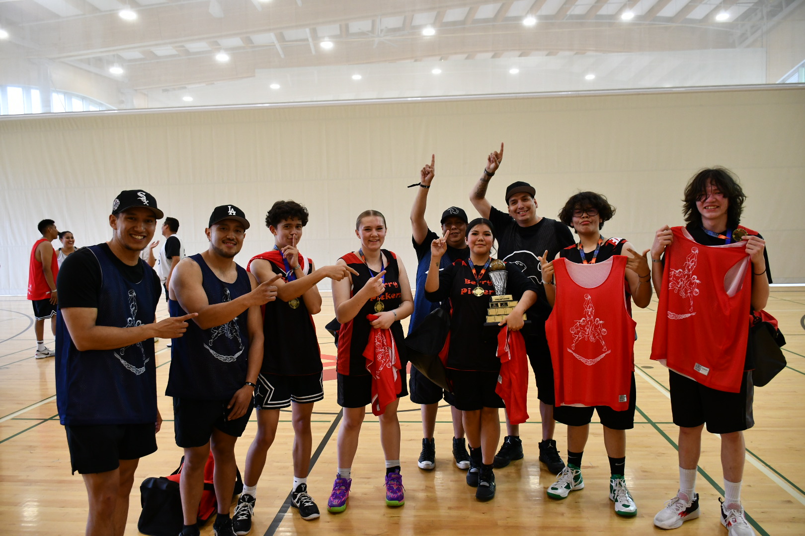 A group of youth pose for a photo after a successful basketball tournament