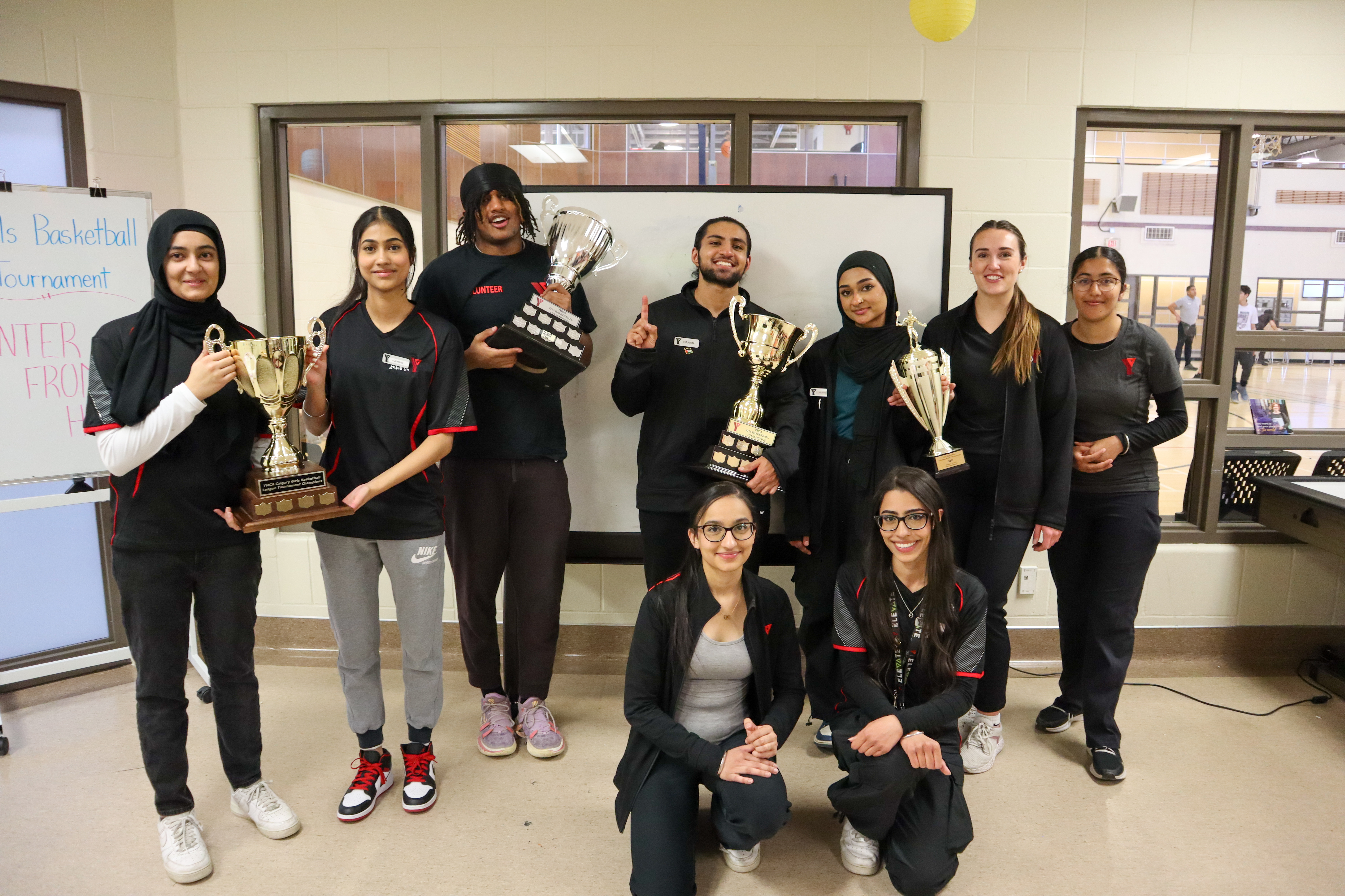 Winners of the YMCA girls basketball tournament pose with their trophies