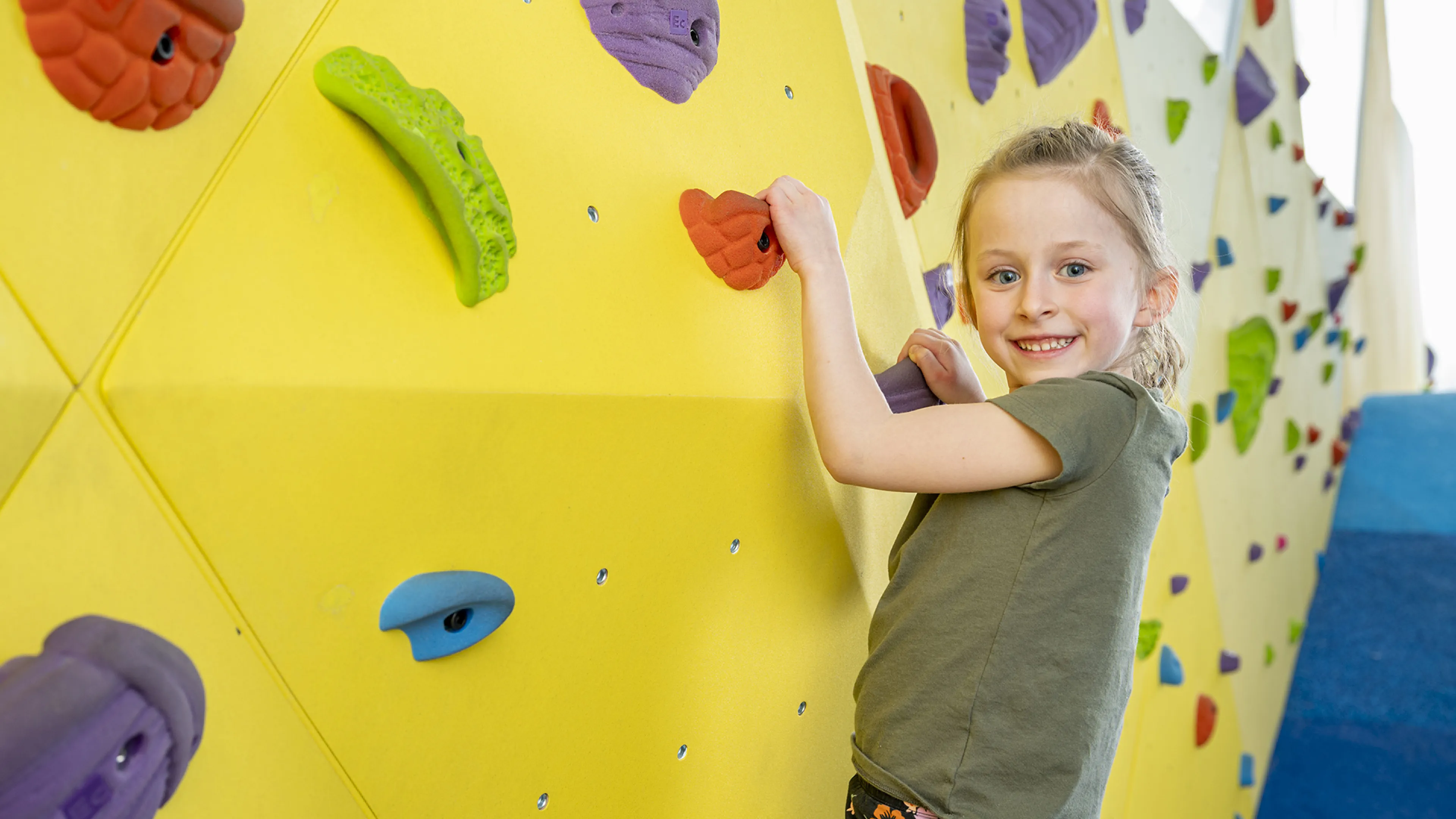 little girl playing on climbing wall
