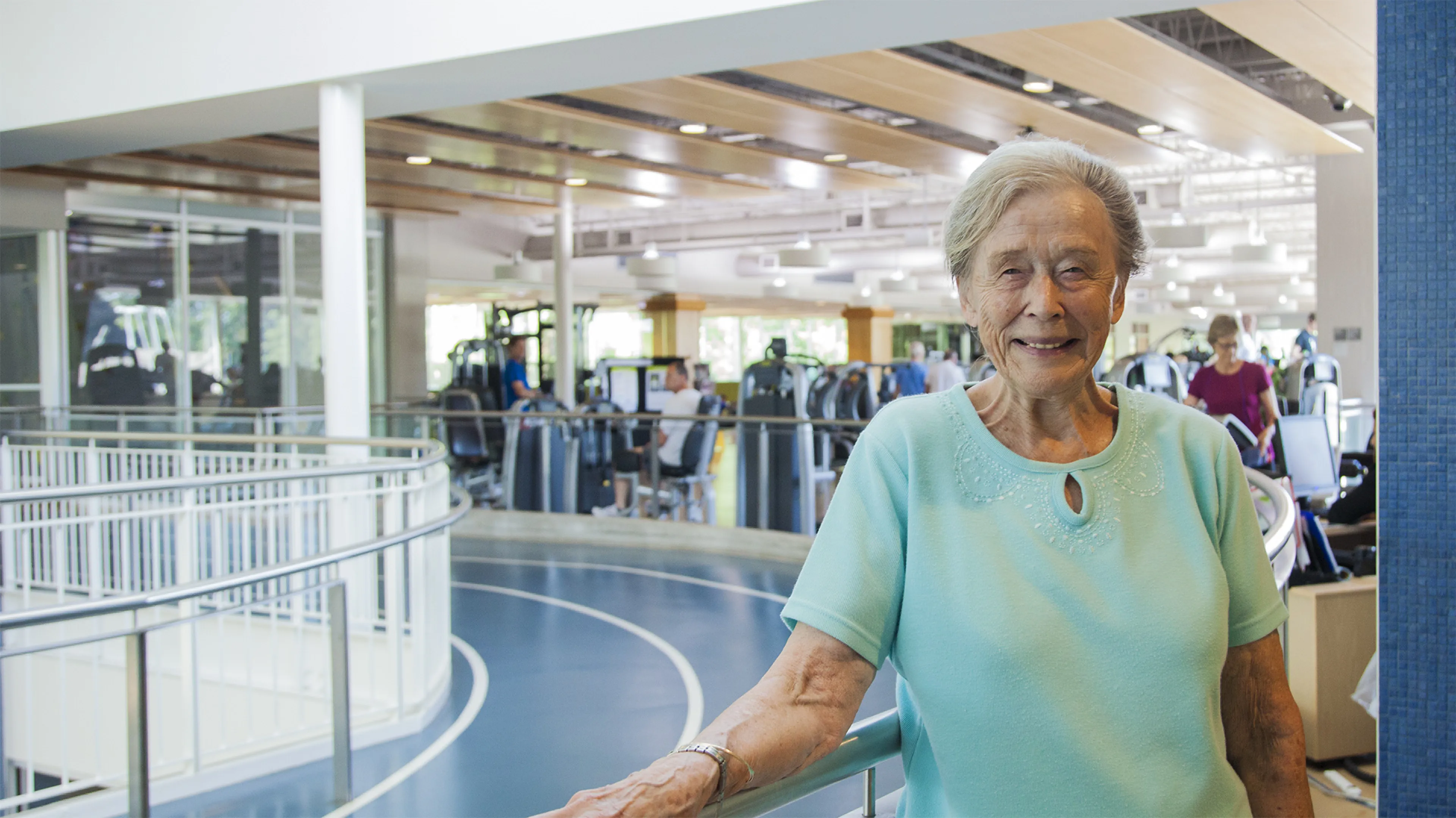 older woman smiling on indoor track