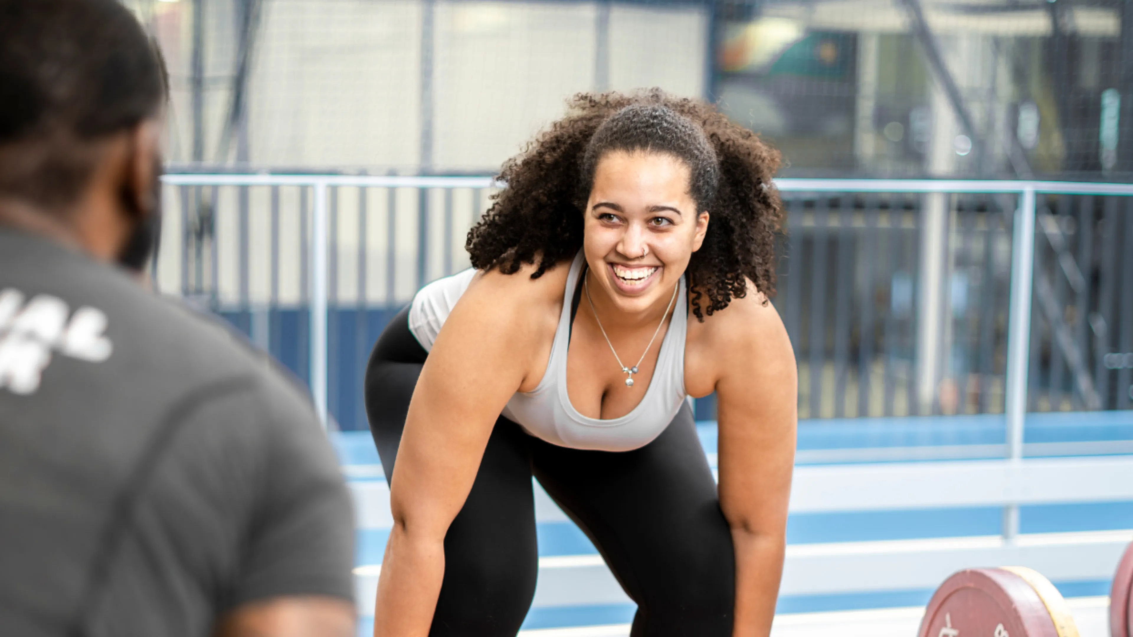 a girl dead lifting weights with a personal trainer