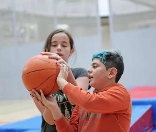 Two youth play basketball