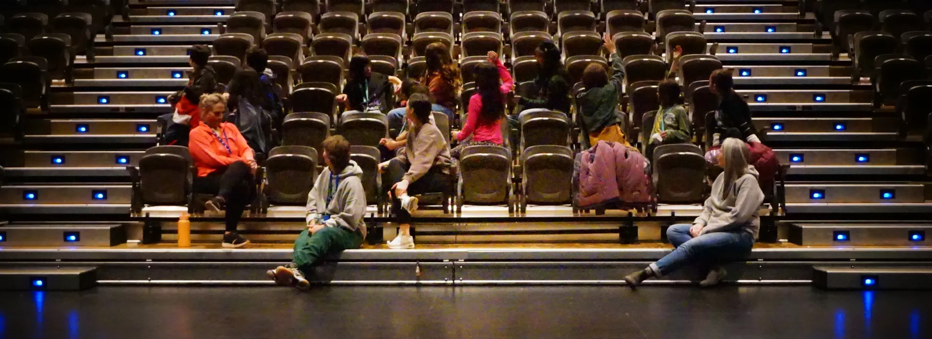 Students waving Hello to the Tech Crew in the theatre