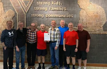 A group of eight older adults standing together smiling
